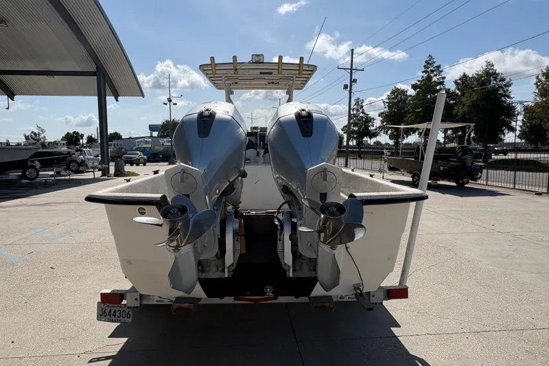 Slide: The Image of 2019 Carolina Skiff 24 DLX with dual outboard motors at a marina. - 5