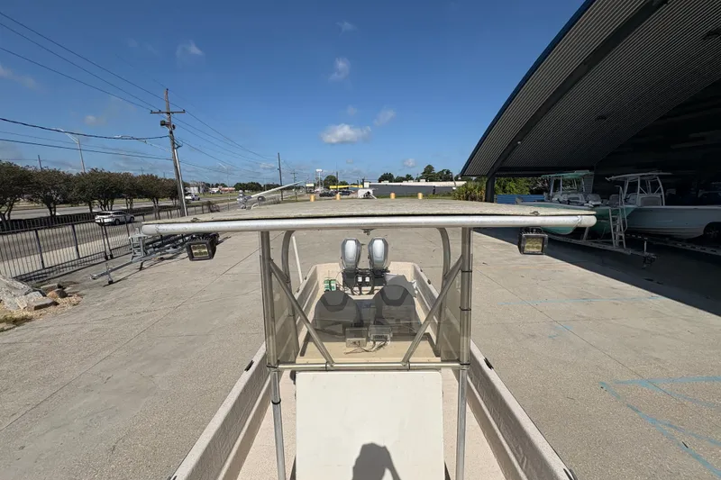 Slide: The Image of 2019 Carolina Skiff 24 DLX boat parked outdoors under clear blue sky. - 12