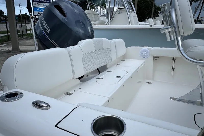 Slide: The Image of 2027 Key West 189 FS boat interior with Yamaha engine, featuring white seating and cup holders. - 18