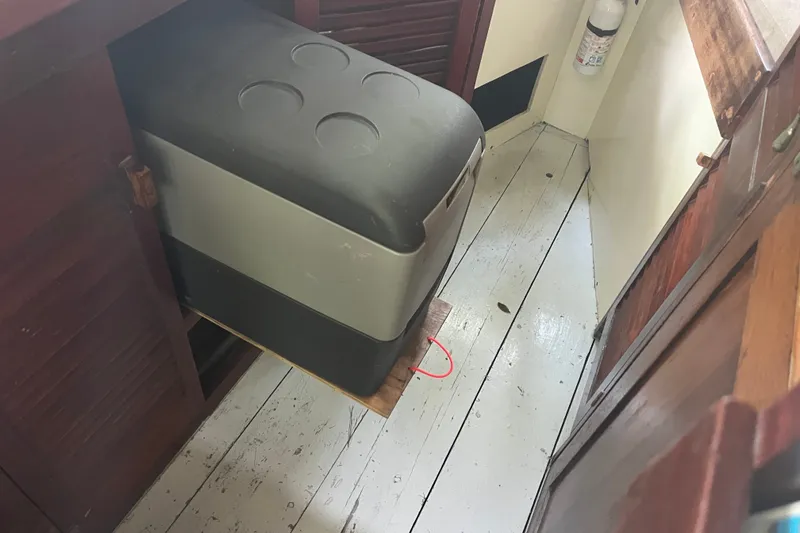 Slide: The Image of 1970 Dyer 29 interior with a portable cooler in a wooden cabinet. - 16