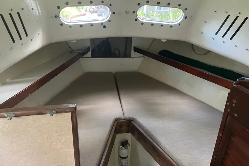 Slide: The Image of Interior cabin of a 1970 Dyer 29 boat, featuring cushioned sleeping area. - 19
