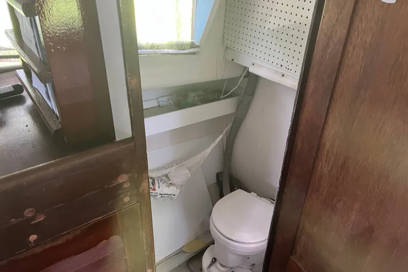 Slide: The Image of Small bathroom on a 1970 Dyer 29 boat with wooden cabinetry and compact toilet. - 17