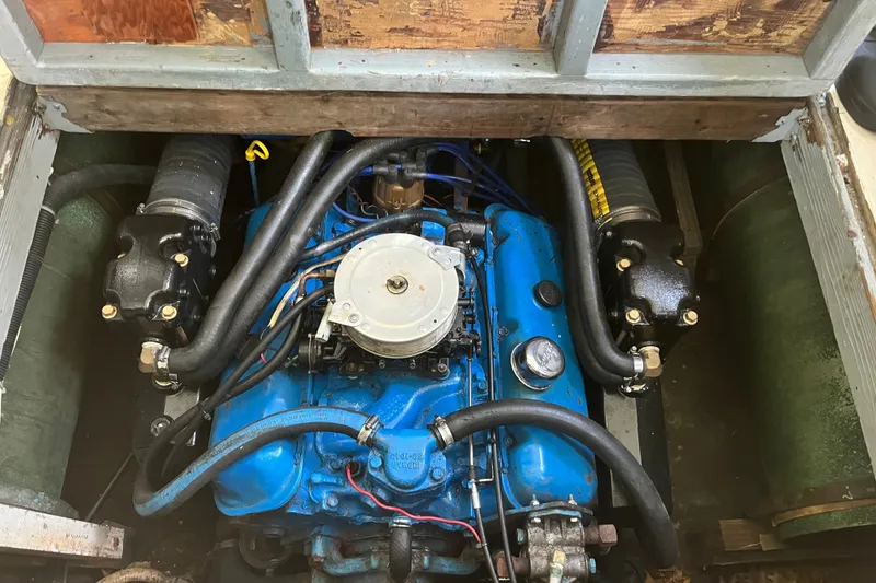 Slide: The Image of A blue engine in a 1970 Dyer 29 boat, surrounded by hoses and mechanical components. - 13