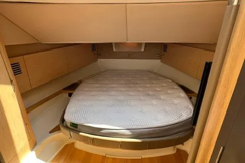 Slide: The Image of 2016 Chris-Craft Launch 36 cabin interior with a cozy bed and wooden accents. - 26