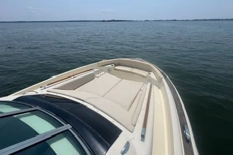 Slide: The Image of 2016 Chris-Craft Launch 36 boat on calm water, featuring spacious deck and seating. - 19