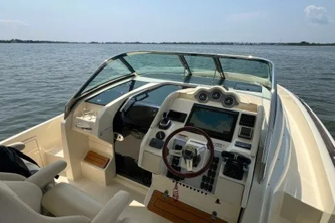 Slide: The Image of 2016 Chris-Craft Launch 36 boat interior with steering wheel and dashboard on open water. - 24
