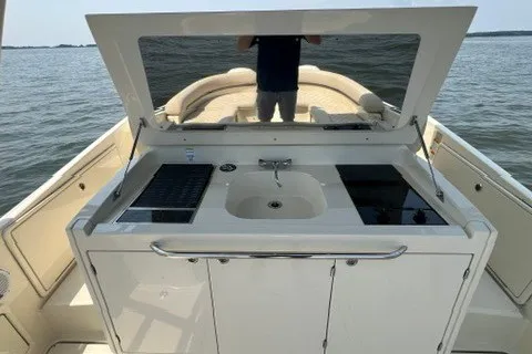 Slide: The Image of 2016 Chris-Craft Launch 36 boat with outdoor kitchenette, featuring sink and grill, on open water. - 22
