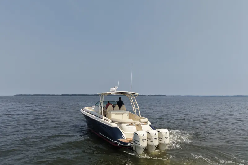 Slide: The Image of 2016 Chris-Craft Launch 36 boat cruising on open water with triple outboard engines. - 5