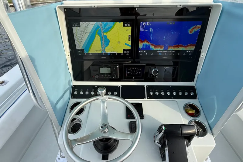 Slide: The Image of Control panel of a 2011 Contender 35 ST boat with navigation screens and steering wheel. - 16