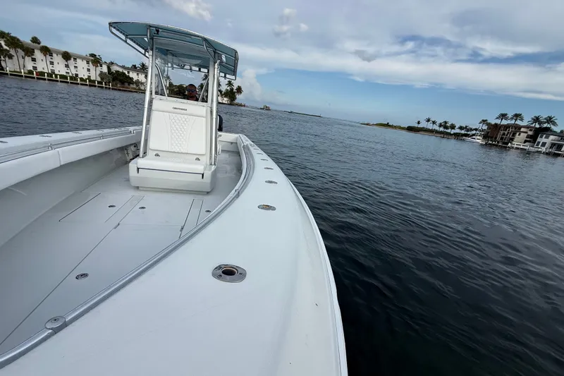 Slide: The Image of 2011 Contender 35 ST boat cruising on calm waters near coastal buildings and palm trees. - 8