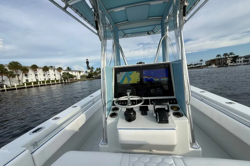 Slide: The Image of 2011 Contender 35 ST boat dashboard with navigation screens on a scenic waterway. - 15