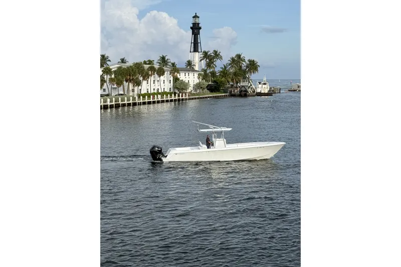 Slide: The Image of 2011 Contender 35 ST boat cruising near a lighthouse and palm trees. - 5