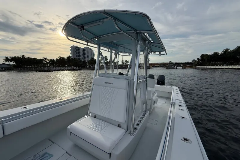 Slide: The Image of 2011 Contender 35 ST boat on water at sunset, featuring sleek design and spacious deck. - 12