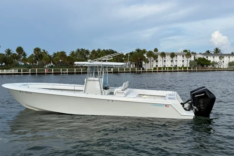 The Image of 2011 Contender 35 ST boat on water, with Mercury engine, near palm-lined shore. - 0
