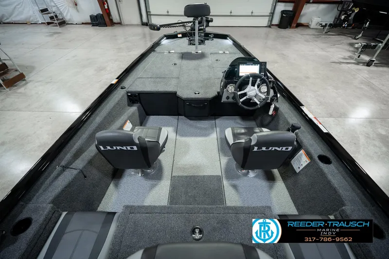 Slide: The Image of 2026 Lund 1875 Renegade boat interior with steering console and seating in showroom. - 17