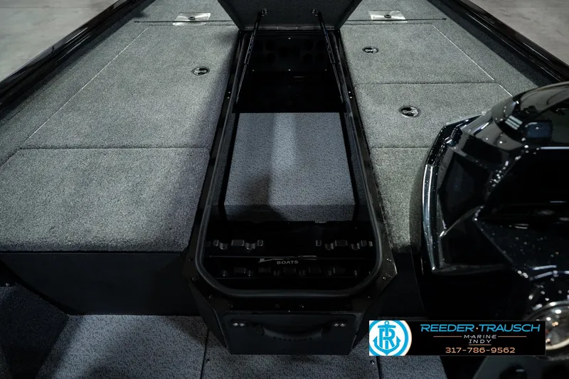 Slide: The Image of 2026 Lund 1875 Renegade boat interior with open storage compartment, gray carpeted surface. - 29