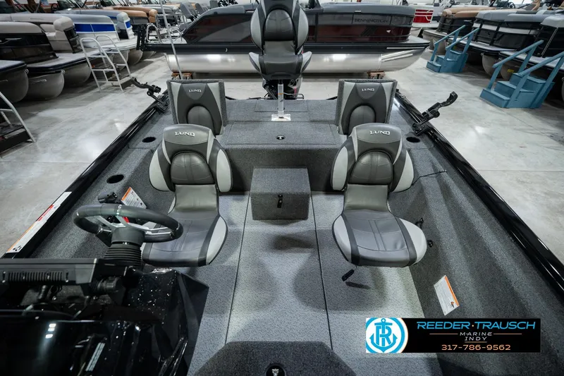 Slide: The Image of 2026 Lund 1875 Renegade boat interior with gray seating, displayed at Reeder-Trausch Marine showroom. - 22