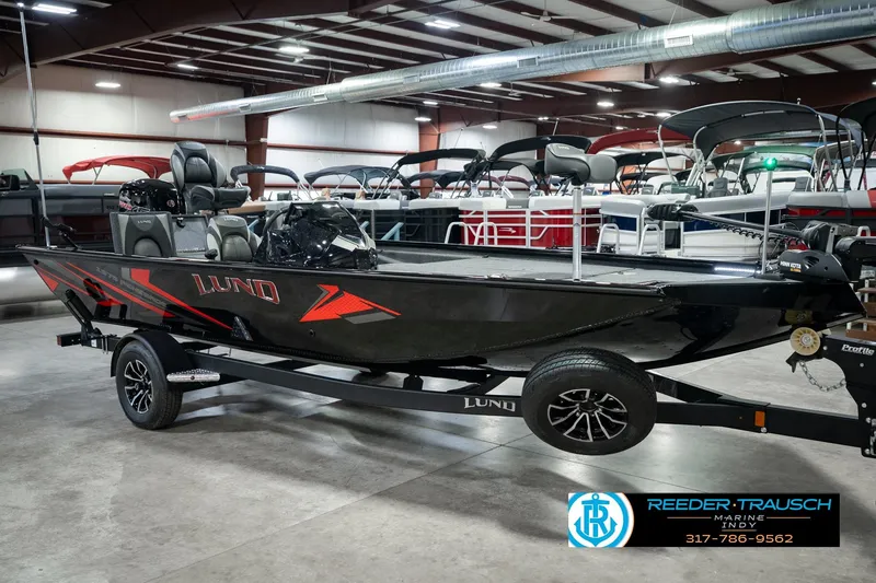 Slide: The Image of 2026 Lund 1875 Renegade boat in showroom, featuring sleek black design and modern equipment. - 4
