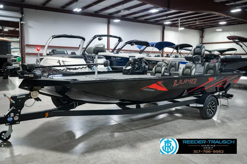 Slide: The Image of 2026 Lund 1875 Renegade fishing boat in showroom, featuring sleek design and modern equipment. - 1