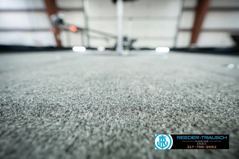 Slide: The Image of 2026 Lund 1875 Renegade boat interior with carpet flooring, Reeder-Trausch Marine logo visible. - 51