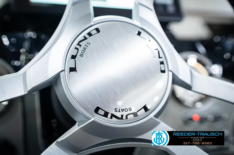Slide: The Image of Steering wheel of 2026 Lund 1875 Renegade boat, featuring sleek metallic design. - 36