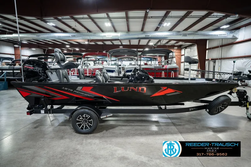 Slide: The Image of 2026 Lund 1875 Renegade boat in showroom, featuring sleek black and red design. - 5