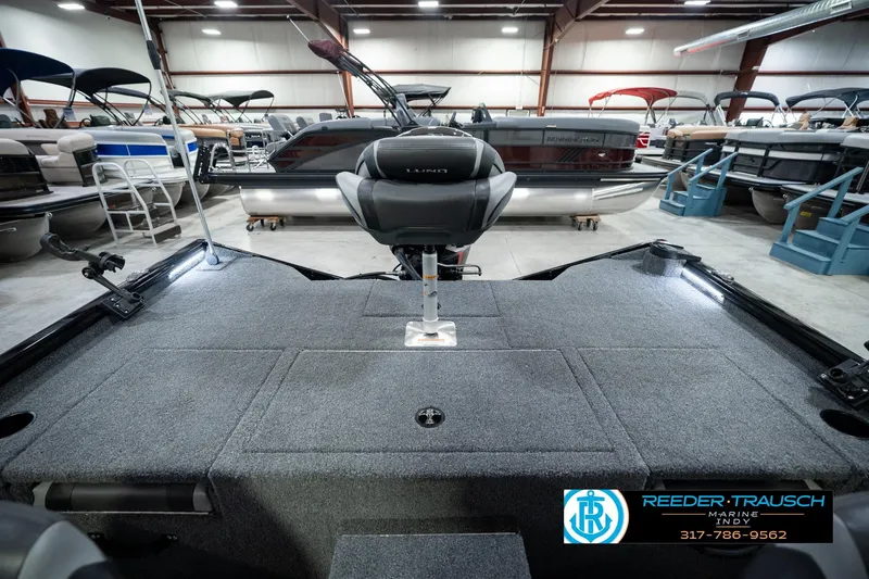 Slide: The Image of 2026 Lund 1875 Renegade boat interior in showroom with seating and storage. - 25
