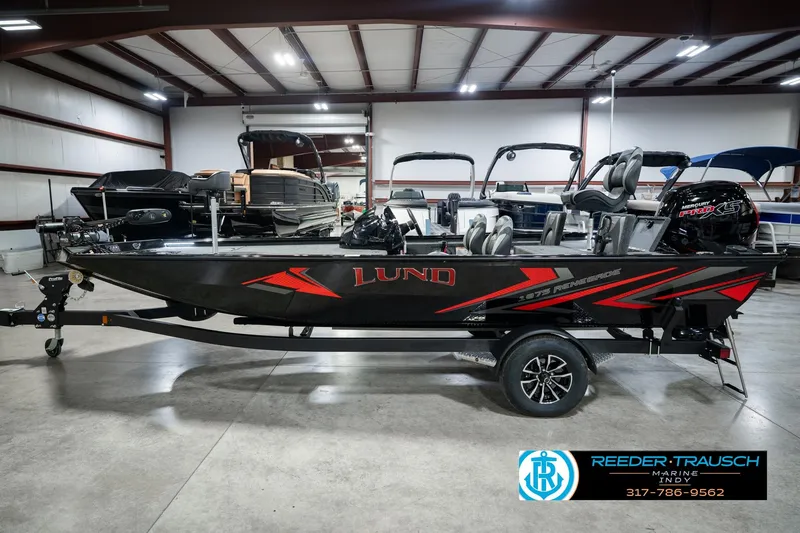 Slide: The Image of 2026 Lund 1875 Renegade fishing boat in showroom, featuring sleek black and red design. - 10