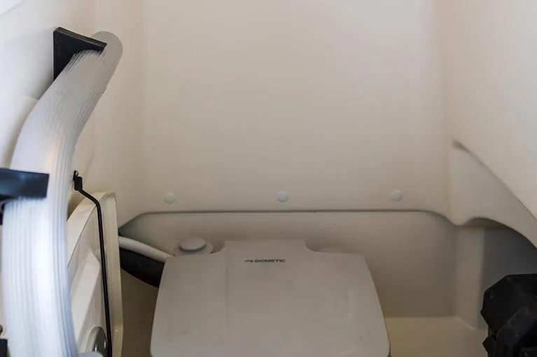 Slide: The Image of Manufacturer Provided Image: Interior of 2026 Boston Whaler 210 Montauk boat featuring a compact marine toilet. - 16