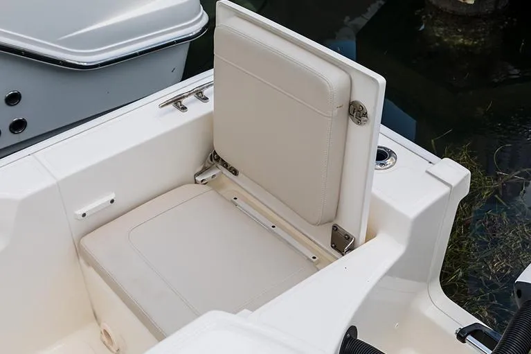 Slide: The Image of Manufacturer Provided Image: 2026 Boston Whaler 210 Montauk boat seat detail, featuring beige upholstery and sleek design. - 14