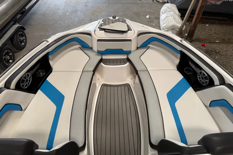 Slide: The Image of 2018 Yamaha Boats 242X E-Series interior with blue and white seating, sleek design. - 7