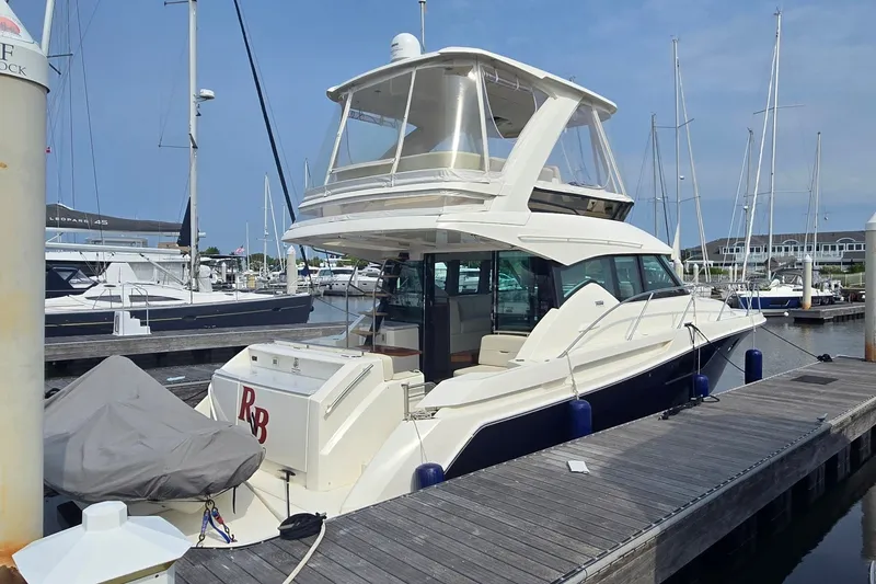 Slide: The Image of 2021 Tiara Yachts F44 Flybridge docked at marina, showcasing sleek design and spacious flybridge. - 3