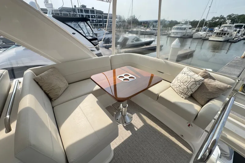 Slide: The Image of Luxurious seating area on 2021 Tiara Yachts F44 Flybridge, featuring elegant cushions and a polished table. - 48