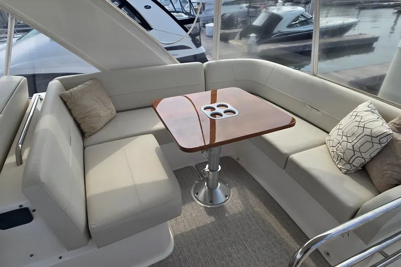 Slide: The Image of Luxurious seating area on 2021 Tiara Yachts F44 Flybridge with elegant table and cushions. - 49