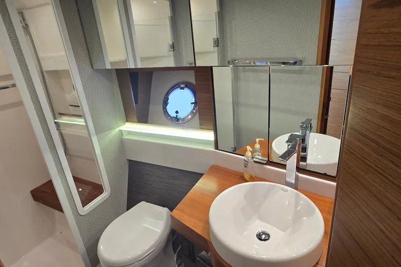 Slide: The Image of Luxurious bathroom in 2021 Tiara Yachts F44 Flybridge with modern fixtures and porthole window. - 30