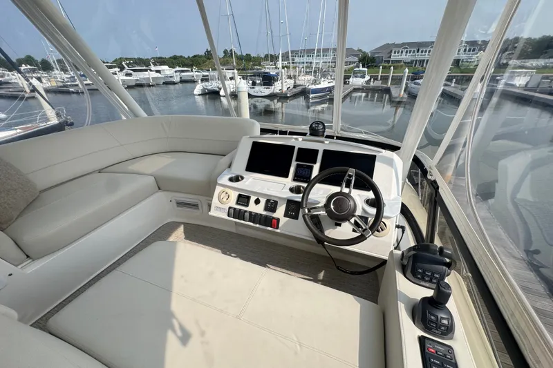 Slide: The Image of 2021 Tiara Yachts F44 Flybridge helm with modern controls and marina view. - 41