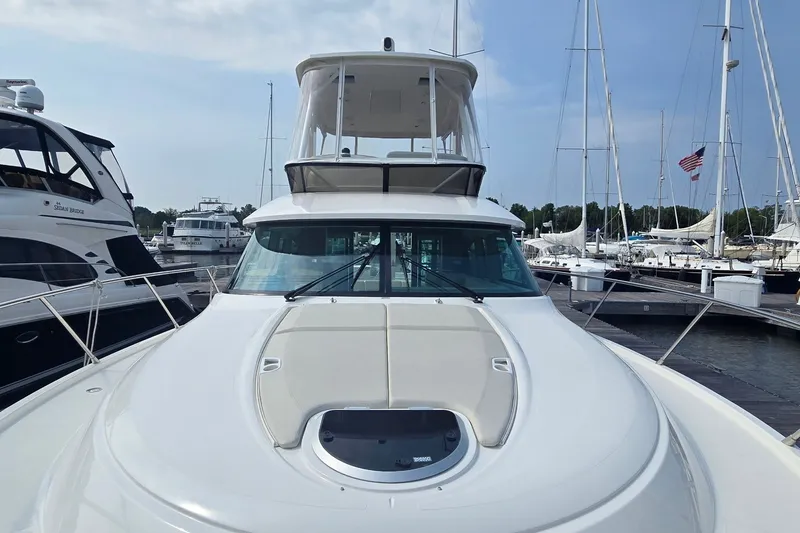 Slide: The Image of 2021 Tiara Yachts F44 Flybridge docked at a marina, showcasing sleek design. - 8