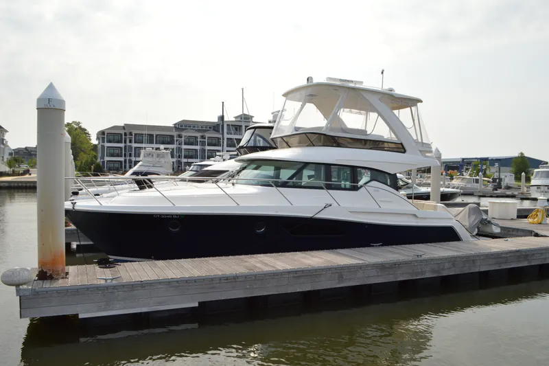 Slide: The Image of 2021 Tiara Yachts F44 Flybridge docked at a marina, showcasing sleek design. - 7