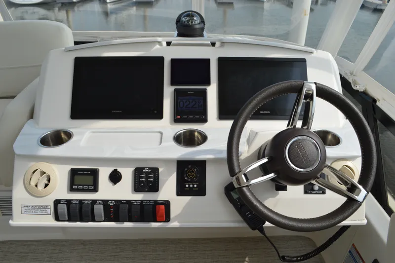 Slide: The Image of 2021 Tiara Yachts F44 Flybridge helm with steering wheel and navigation displays. - 44