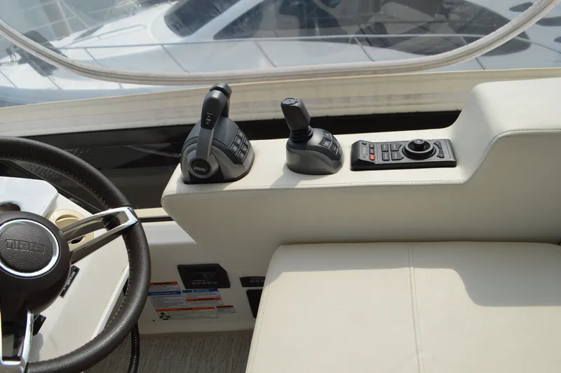 Slide: The Image of Tiara Yachts F44 Flybridge 2021 helm controls with steering wheel and throttle levers. - 45