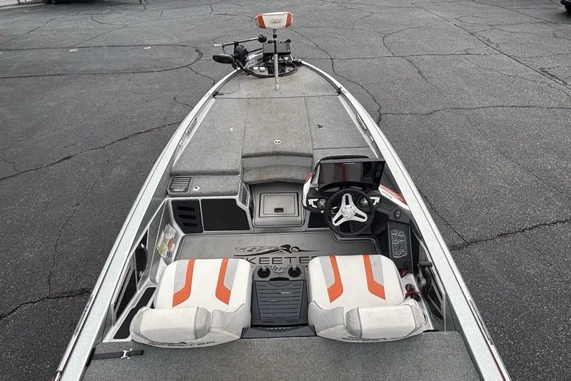 Slide: The Image of 2018 Skeeter FX21 boat interior with steering wheel and seating, parked on asphalt. - 30
