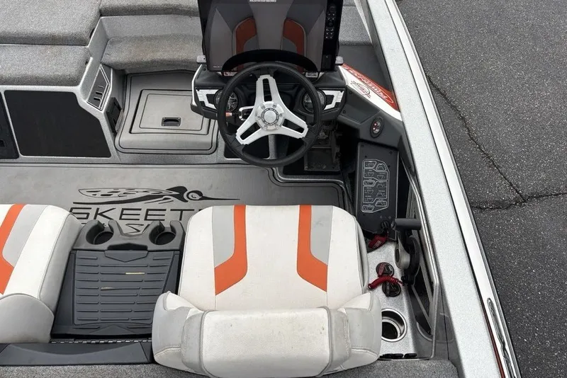 Slide: The Image of 2018 Skeeter FX21 boat interior with steering wheel, control panel, and seating. - 16