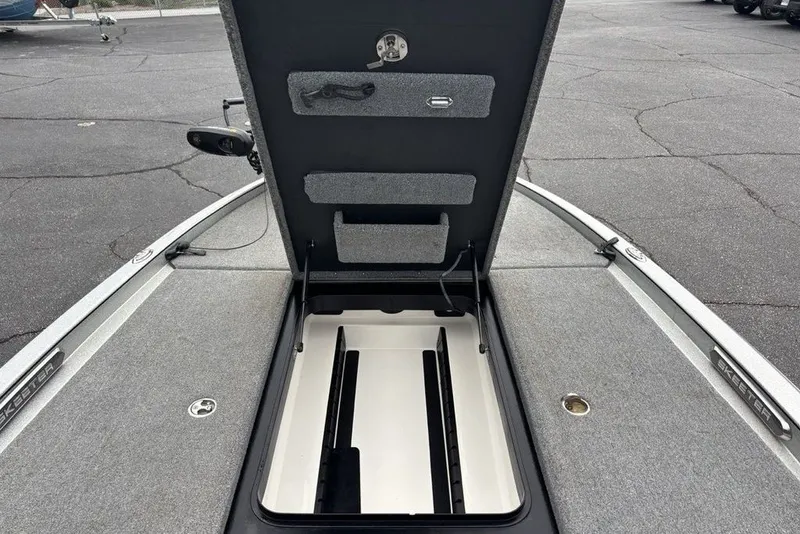 Slide: The Image of 2018 Skeeter FX21 boat storage compartment open, showcasing interior space and carpeted lid. - 14