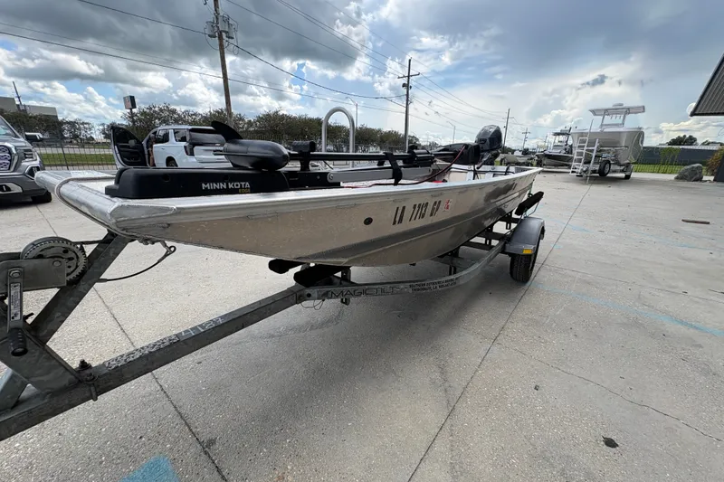Slide: The Image of Custom 2023 aluminum fishing boat on trailer with Minn Kota motor, parked outdoors. - 7