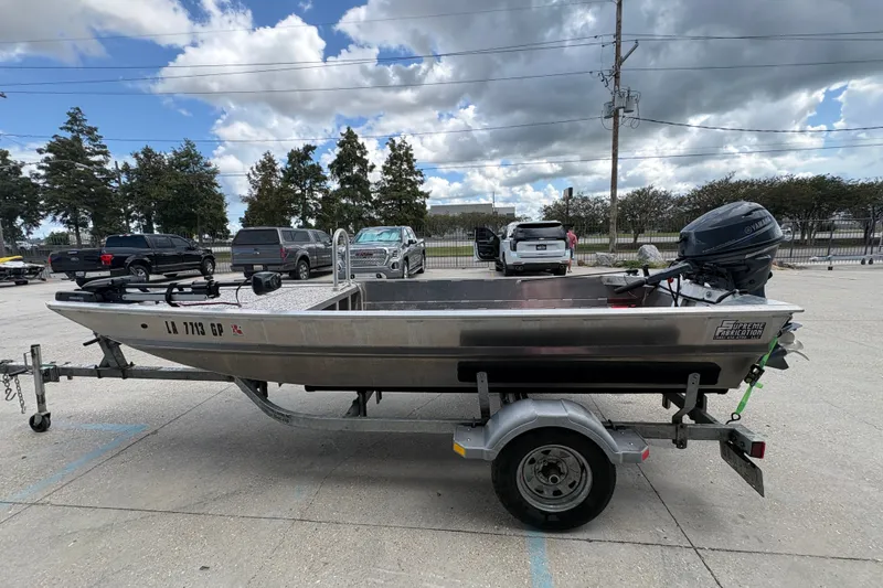 Slide: The Image of Custom 2023 aluminum boat on trailer with Yamaha outboard motor, parked in lot under cloudy sky. - 6