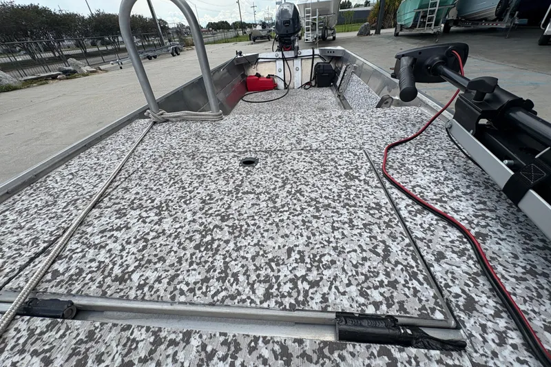 Slide: The Image of Custom 2023 model 14 boat with speckled deck, motor, and equipment in a marina setting. - 18