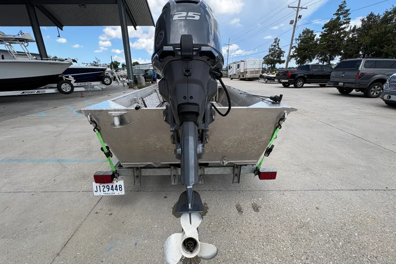 Slide: The Image of Aluminum boat with 25 HP outboard motor on trailer, parked in marina lot. - 4