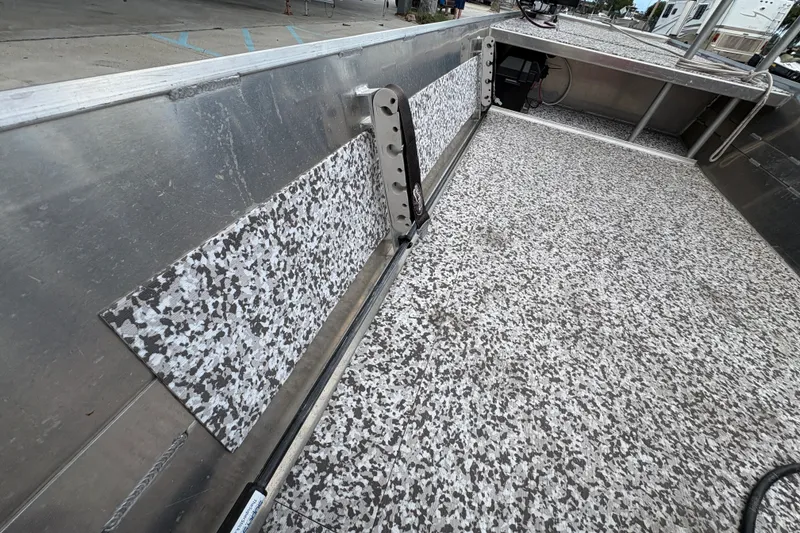Slide: The Image of Interior of a 2023 Custom model 14 boat with speckled flooring and metal siding. - 16