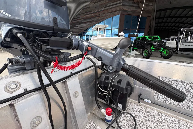 Slide: The Image of Close-up of a 2023 Custom 14 boat motor handle with control cables and safety cord. - 20