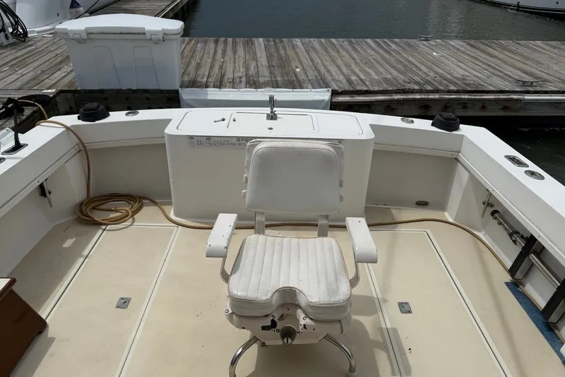 Slide: The Image of 2002 Carolina Classic 28 boat interior with fishing chair and dock view. - 13